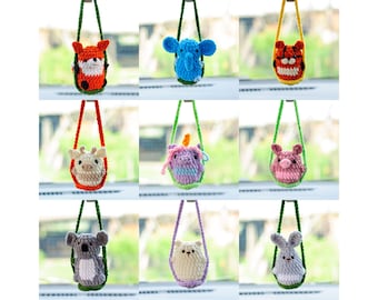 May include: Nine crocheted animal plushies hanging from green strings. The plushies are a fox, elephant, tiger, giraffe, unicorn, pig, koala, bear, and rabbit. Each plushie is in a different color and has a different expression.