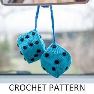 May include: Two blue crocheted dice with black dots hanging from a rearview mirror.  Crochet pattern.