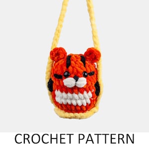May include: A crocheted tiger-shaped purse with a yellow strap. The purse is made of orange, white, and black yarn.