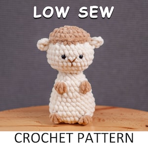 May include: Crochet pattern for a low-sew amigurumi lamb. The lamb is white with brown fur on its head and has black eyes. The pattern is called "Low Sew Crochet Pattern".