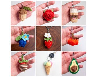 May include: Nine crocheted keychain charms, each featuring a different design: an acorn, a rose, a coffee cup, a blueberry, a strawberry, a pumpkin, a chocolate-covered strawberry, an ice cream cone, and an avocado.