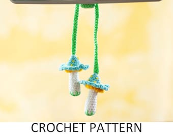 May include: Two crocheted mushroom charms hanging from a green string. The mushrooms have blue and yellow caps and white stems.