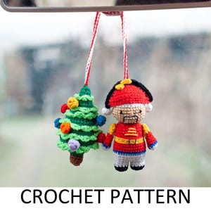 Może przedstawiać: Wzór na szydełku na choinkę i zabawkę żołnierza. Choinka jest zielona z kolorowymi ozdobami, a żołnierz ma na sobie czerwony i niebieski mundur z czarnym kapeluszem.