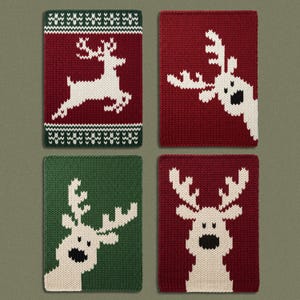 May include: Four rectangular knitted fabric pieces featuring holiday-themed reindeer designs. Two pieces are deep red with white reindeer, one is dark green with a white reindeer, and one is red with a white reindeer peeking from the side.