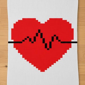 Può includere: Asciugamano rettangolare bianco con un grande cuore rosso pixelato e una linea nera del battito cardiaco. Realizzato in un materiale morbido e strutturato, ideale per il bagno o la cucina.