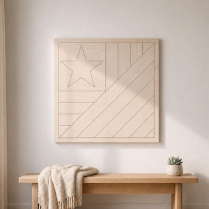 May include: A wooden wall art piece with a star and stripe design, resembling a flag. The artwork is mounted on a light-colored wall above a wooden bench. A beige throw blanket with fringe and a small potted plant are on the bench.