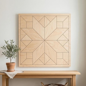 May include: A large, square wooden wall art piece with a geometric starburst design. The artwork is made of light-colored wood with dark brown lines outlining the star and geometric shapes. A small potted plant sits on a wooden table below.