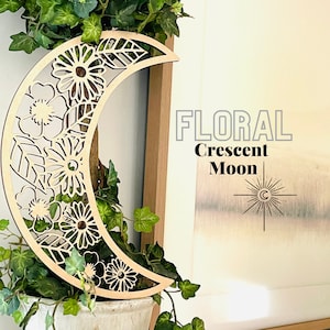 May include: A wooden crescent moon wall decoration featuring a floral design. The moon is cut out with intricate details of flowers and leaves. The text "FLORAL Crescent Moon" is visible in the background.