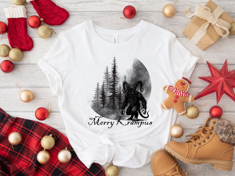 May include: White t-shirt with a black and white illustration of a monster with horns and a forest in the background. The text "Merry Krampus" is printed below the illustration.