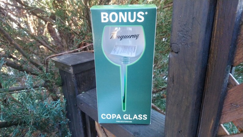 May include: A green box with the word "BONUS" in white at the top. The box features a large illustration of a copa glass with the Tanqueray logo. The words "COPA GLASS" are printed at the bottom.