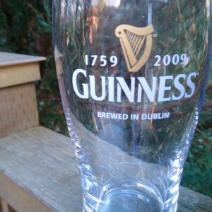 May include: A clear glass pint glass with the Guinness logo and the text "1759 GUINNESS 2009 Brewed in Dublin".