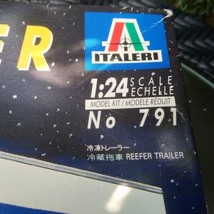 May include: A model kit box with a dark blue background and white speckles. The box features the Italeri logo, scale information (1:24), and the text "REEFER TRAILER". The model kit number is 791.