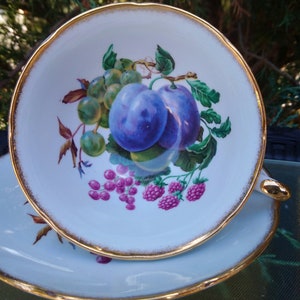 Vintage Royal Grafton, porcelana fina, Inglaterra, xícara de chá e pires com pés, marca 1957+, decoração de frutas multicoloridas, borda recortada, acabamento dourado