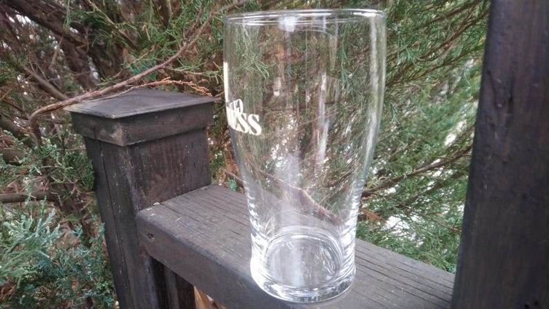 Puede incluir: Un vaso de pinta de vidrio transparente con la palabra "Guinness" impresa en el lateral.