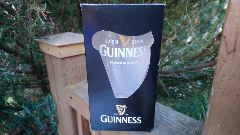 May include: A black box with a clear glass Guinness pint glass inside. The box has the Guinness logo and the text "1759 2009 Guinness Brewed in Dublin" printed on it.