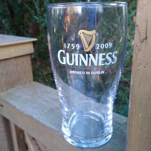 May include: A clear glass pint glass with the Guinness logo and the text "1759 GUINNESS 2009 Brewed in Dublin".