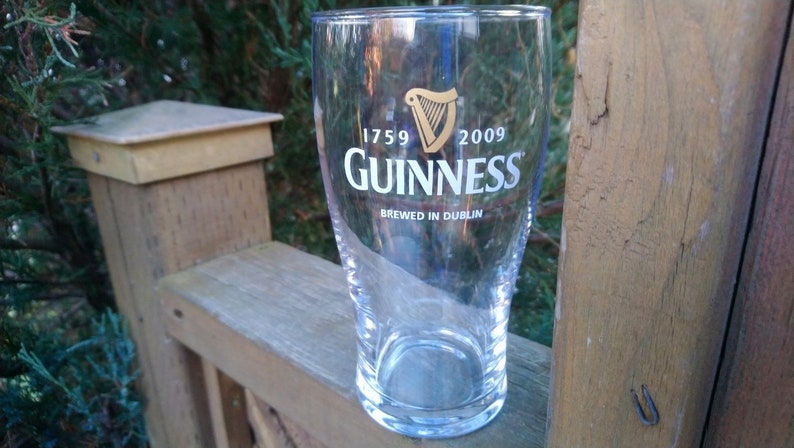 May include: A clear glass pint glass with the Guinness logo and the text "1759 GUINNESS 2009 Brewed in Dublin".