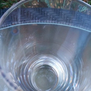 May include: A clear glass drinking glass with a wide mouth and a thick base. The glass is empty and appears to be clean.