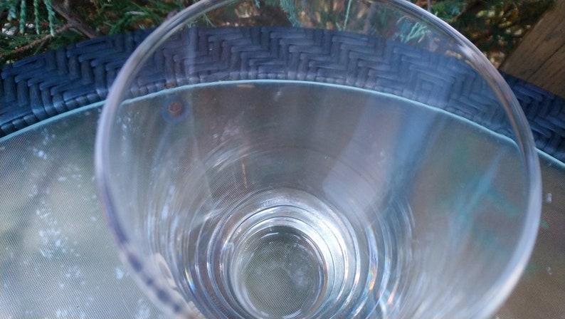 May include: A clear glass drinking glass with a wide mouth and a thick base. The glass is empty and appears to be clean.