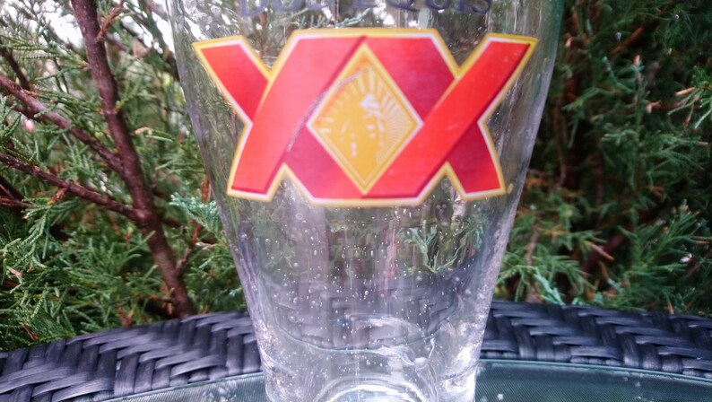 May include: A clear glass beer mug with a red and yellow logo that says "XX" on it.