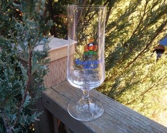 Op de afbeelding: Een helder glazen bierglas met een blauw-wit logo met de tekst "Kronenbourg 1664" en een kroon en een hop plant.