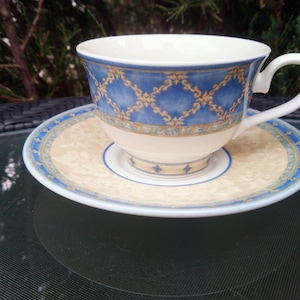 May include: A blue and white teacup and saucer set with a floral pattern. The saucer has a gold trim.
