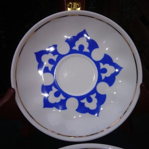Può includere: Piatto bianco con un motivo floreale blu e bianco. Il piatto ha un bordo dorato.