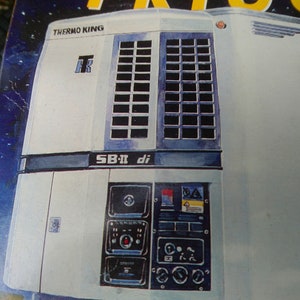 May include: Illustration of a Thermo King SB-II di refrigeration unit. The unit is primarily white with dark blue accents and features a grid-like vent design. The Thermo King logo is visible.