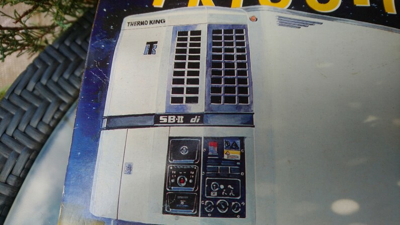 May include: Illustration of a Thermo King SB-II di refrigeration unit. The unit is primarily white with dark blue accents and features a grid-like vent design. The Thermo King logo is visible.
