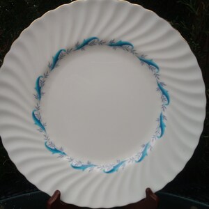 May include: White ceramic dinner plate with a blue and white floral design around the rim.