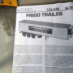 May include: A black and white diagram of a Frigo Trailer model, scale 1:24, with the name "ALBATROS" on the side. The model has six wheels and is a refrigerated trailer. The text "FRIGO TRAILER" is at the top.