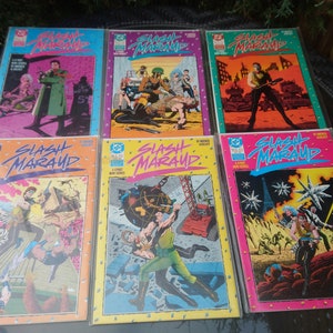 May include: A collection of eight comic books featuring the title "Slash Maraud" on the cover. The covers are colorful and feature various characters and scenes from the comic book series.