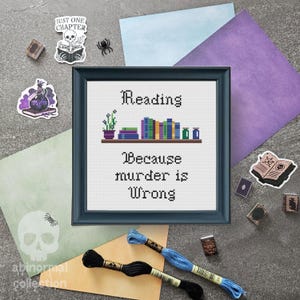 May include: A blue and white cross-stitch pattern with the text "Reading because murder is wrong". The pattern features a bookshelf with books and a potted plant.