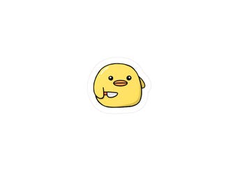 May include: A yellow cartoon chick sticker with a knife. The chick has a round body, a small orange beak, and black eyes. The knife is held in its right wing. The sticker has a white border.
