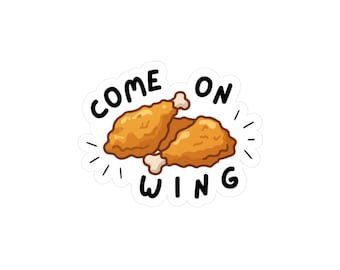 May include: A sticker featuring two cartoon fried chicken wings with the text "COME ON WING" in black, outlined in white. The wings are golden brown with a white background.