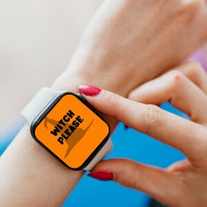May include: A white smartwatch with a black screen displaying the text "WITCH PLEASE" in white letters and a brown witch hat graphic on an orange background. The watch is on a wrist with red nail polish.