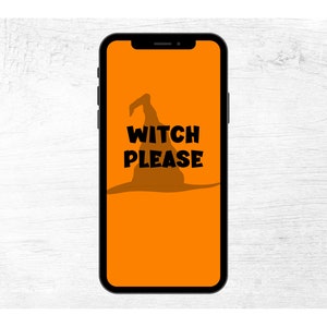May include: A smartphone displays an orange background with a black witch hat silhouette and the words "WITCH PLEASE" in bold black letters. The phone is black and is set against a white wood grain background.