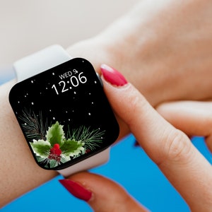 May include: A white smartwatch with a black face displaying the time 12:06 and the date WED 9. The watch face has a black and white design with a green holly sprig and red berries.