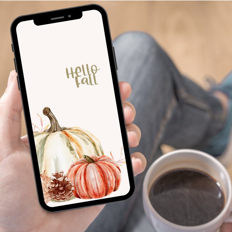 Puede incluir: Un tel&eacute;fono inteligente que muestra un fondo de pantalla de oto&ntilde;o con el texto "hello fall" y una ilustraci&oacute;n de acuarela de calabazas y una pi&ntilde;a.