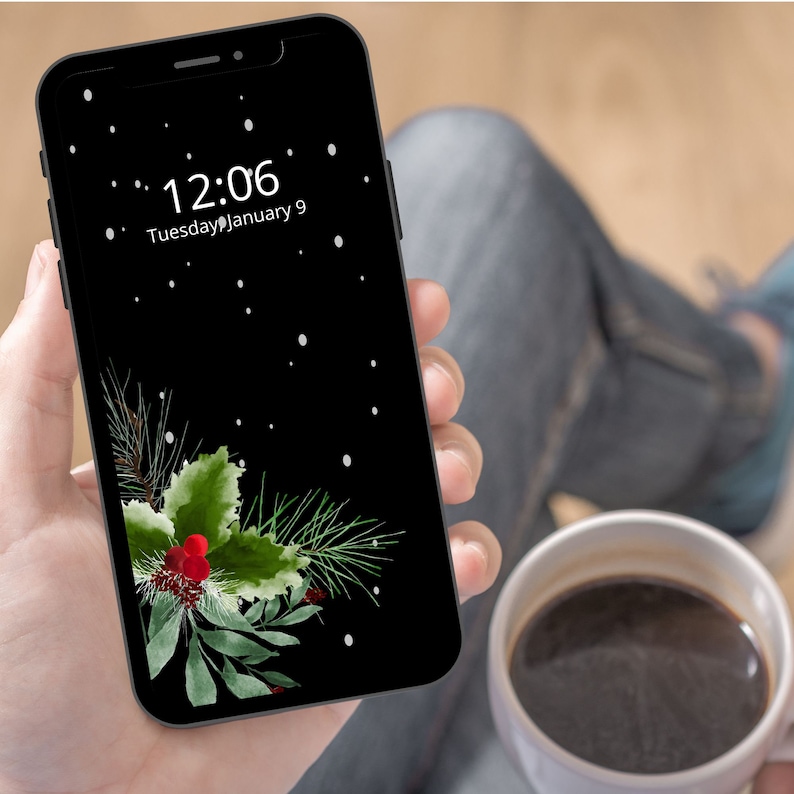 May include: A black smartphone with a dark green and red holly sprig design on the screen. The time is 12:06 and the date is Tuesday, January 9.