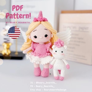 Puede incluir: Una muñeca y un unicornio de ganchillo, ambos en blanco, rosa y amarillo. La muñeca tiene pelo rubio, un vestido rosa y alas blancas. El unicornio tiene un cuerno y pezuñas rosas. La imagen incluye el texto "PDF Pattern!"