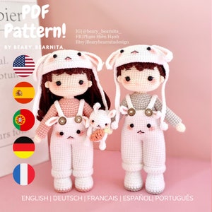 May include: A crochet pattern for two amigurumi dolls, a girl and a boy, wearing bunny hats and dungarees. The dolls are holding small bunny plushies. The pattern is available in English, German, French, Spanish, and Portuguese.