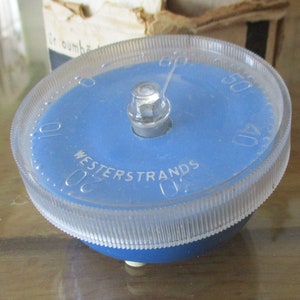 May include: A blue plastic timer with a clear plastic cover. The timer has a dial with numbers from 0 to 60 and the text "WESTERSTRANDS" printed on it.
