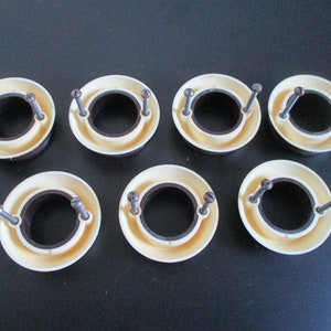 May include: Six white plastic rings with a brown inner ring and two screws on each ring.