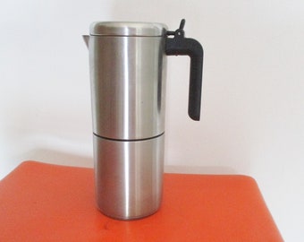 May include: A silver and black stainless steel stovetop espresso maker with a black handle.