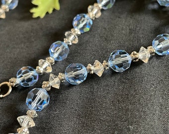May include: A delicate blue and silver crystal beaded bracelet. The bracelet features faceted blue beads and smaller clear crystal beads.