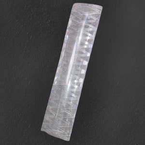 May include: A clear glass rolling pin with a textured surface. The rolling pin is approximately 25 cm long.