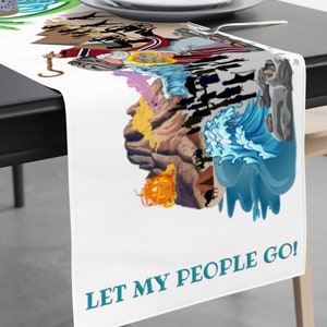 May include: White table runner with a colorful illustration featuring a figure with a staff, waves, and the text "LET MY PEOPLE GO!" The design includes various colors and a detailed graphic.