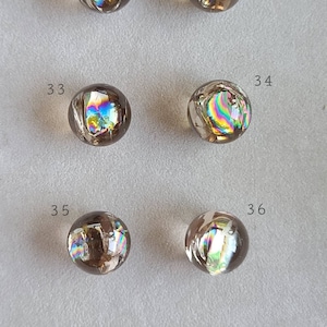 Può includere: Sei sfere marroni iridescenti con motivi arcobaleno. Le sfere sono numerate da 31 a 36.
