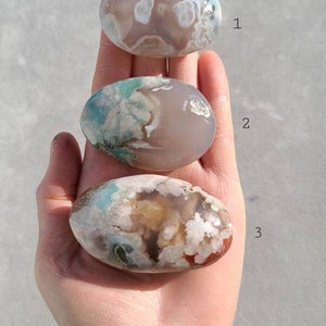 Può includere: Tre pietre di palma di agata con diversi motivi di bianco, marrone e verde. Le pietre sono numerate da 1 a 3.